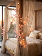 Sakura LED Cherry Blossom Vine Lights, pink, draped on sheer curtain beside canopy bed