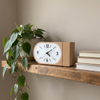 Ember Curved Retro Desk Clock on a floating shelf with plant and books